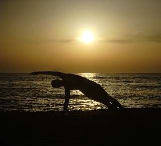 Pilates exercise Side Bend on the beach