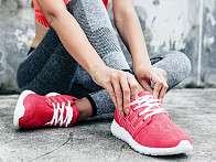 Frau bindet Turnschuhe