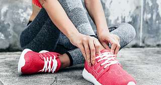 Frau zieht Turnschuhe an